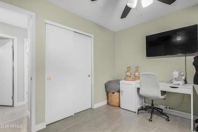 office area with a ceiling fan and baseboards