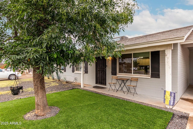 exterior space featuring concrete block siding and a yard