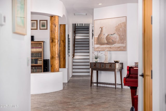 corridor featuring arched walkways and stairway