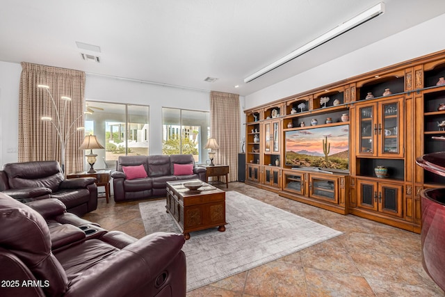 living room featuring stone finish flooring and visible vents