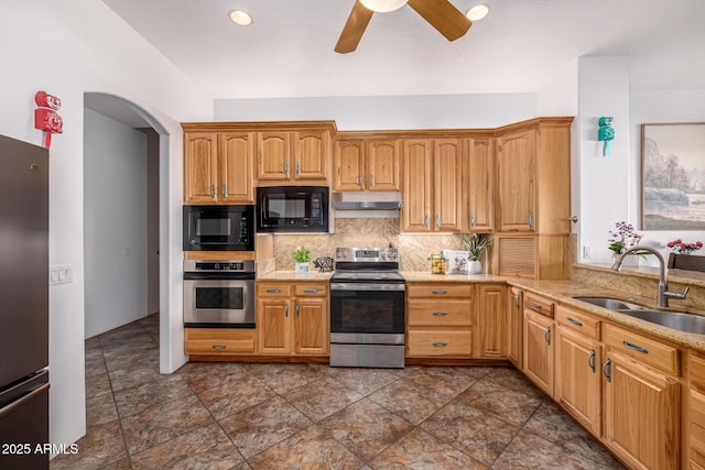 kitchen with tasteful backsplash, under cabinet range hood, ceiling fan, stainless steel appliances, and a sink