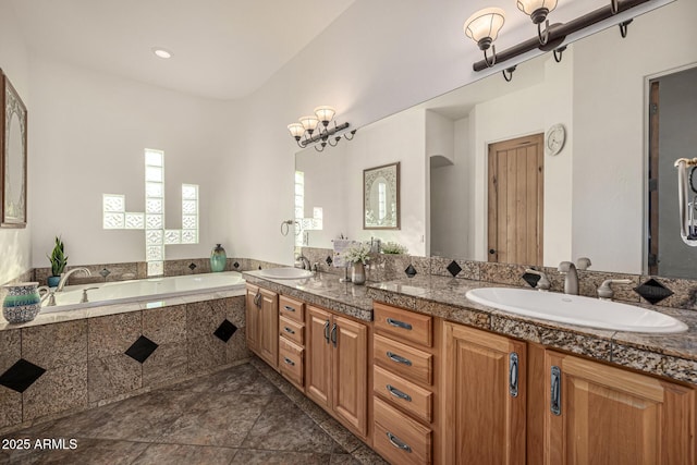 bathroom with double vanity, a bath, and a sink