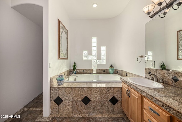full bath featuring a bath, vanity, and a notable chandelier