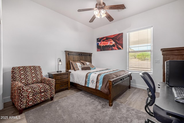 bedroom featuring light wood-style flooring, a ceiling fan, baseboards, and lofted ceiling
