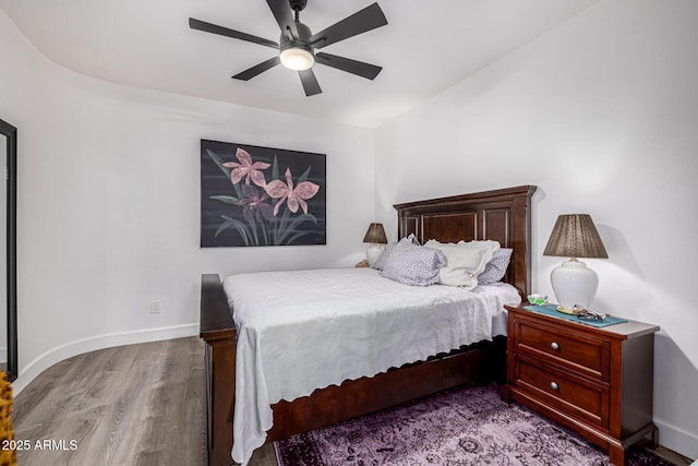 bedroom with wood finished floors, baseboards, and a ceiling fan