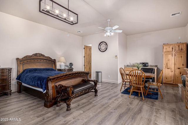 bedroom with wood finished floors, baseboards, and visible vents