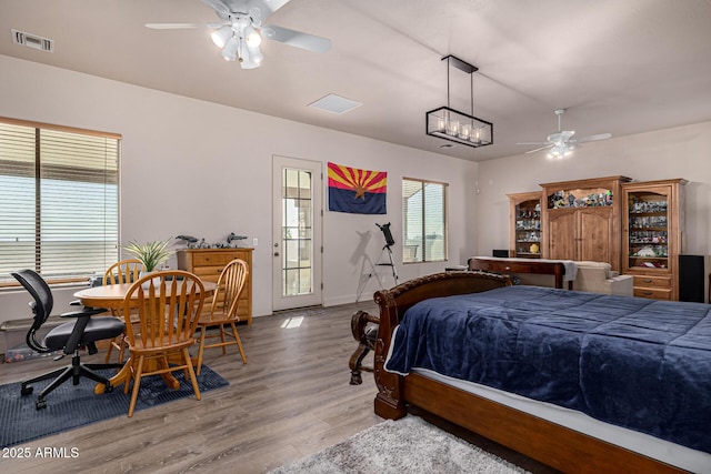bedroom with visible vents, baseboards, a ceiling fan, and wood finished floors