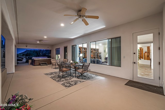 view of patio / terrace with ceiling fan, outdoor dining space, and a hot tub