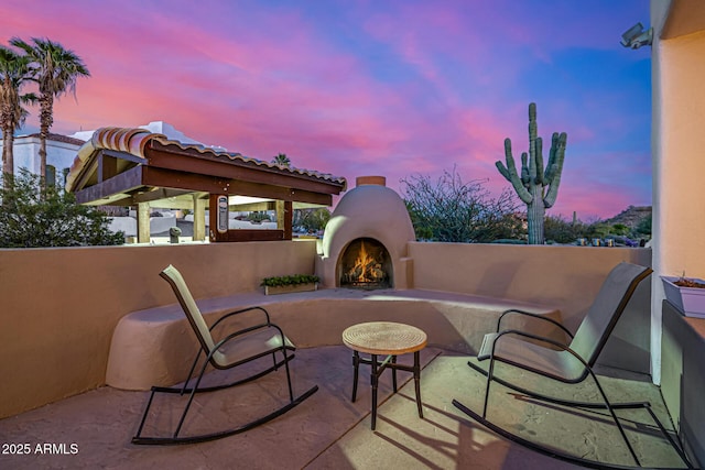 view of patio with an outdoor living space with a fireplace