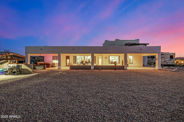 back of house featuring a patio area, outdoor lounge area, and stucco siding