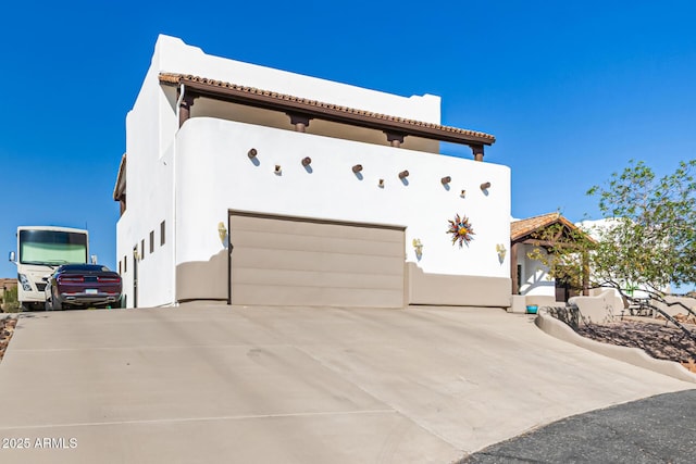 view of side of property featuring an attached garage, driveway, and stucco siding