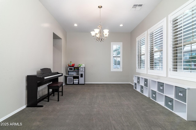 misc room with an inviting chandelier and dark carpet