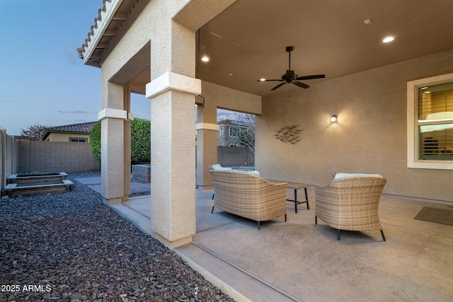 patio terrace at dusk featuring an outdoor hangout area and ceiling fan