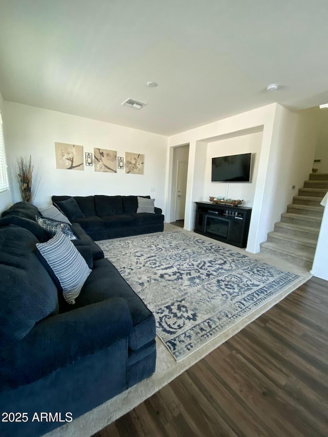 living area with stairway, wood finished floors, and visible vents