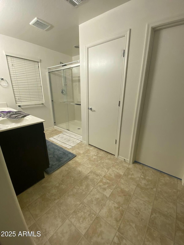 bathroom featuring visible vents, vanity, and a shower stall