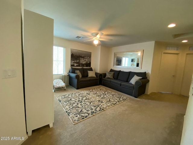 carpeted living room with visible vents and ceiling fan