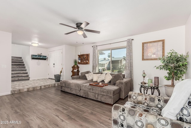 living room featuring stairway, wood finished floors, a ceiling fan, and baseboards