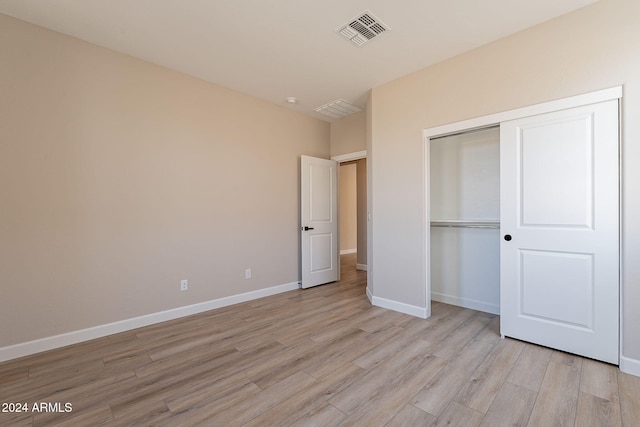 unfurnished bedroom with a closet and light wood-type flooring