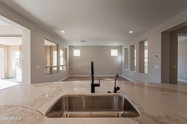 kitchen with light stone counters and sink