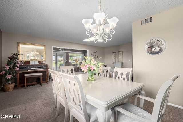 dining area with a notable chandelier, a textured ceiling, and carpet