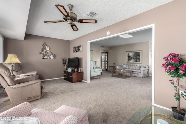 living room featuring ceiling fan, carpet flooring, and a textured ceiling