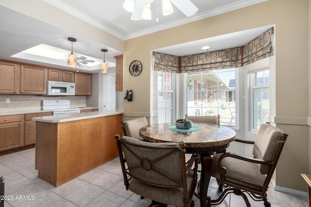 kitchen with pendant lighting, white appliances, ceiling fan, ornamental molding, and kitchen peninsula