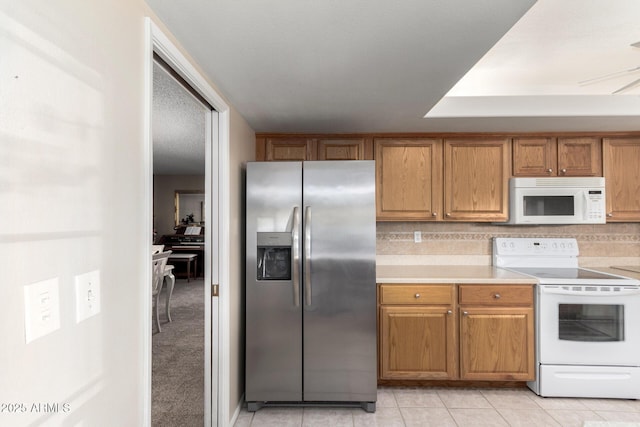 kitchen featuring white appliances, light colored carpet, and decorative backsplash