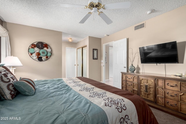 carpeted bedroom with ceiling fan and a textured ceiling