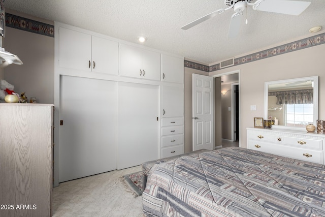 bedroom featuring ceiling fan, a closet, and a textured ceiling