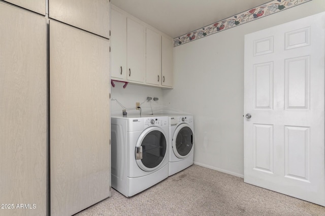 laundry room with cabinets, washing machine and clothes dryer, and light colored carpet