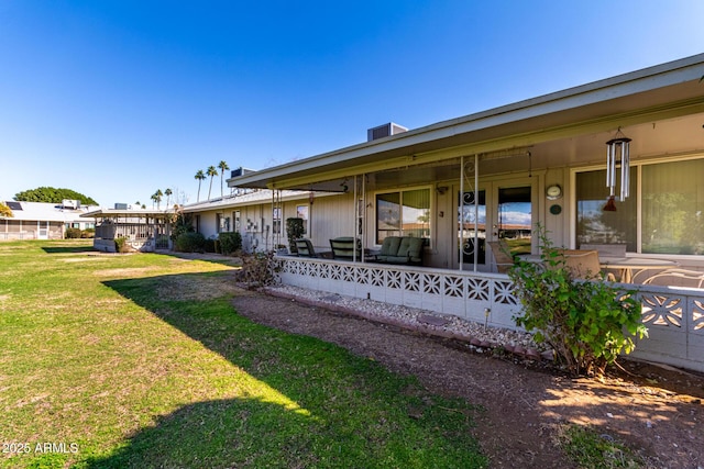 back of house with a yard and covered porch