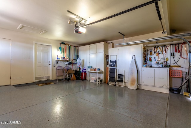 garage featuring a garage door opener and a workshop area