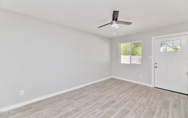 interior space with light wood-style floors, baseboards, and a ceiling fan