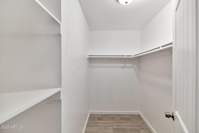 walk in closet with wood tiled floor
