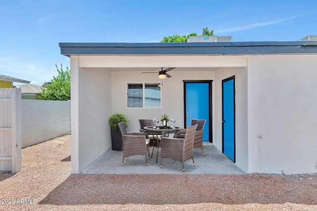 view of patio featuring outdoor dining space, fence, and ceiling fan