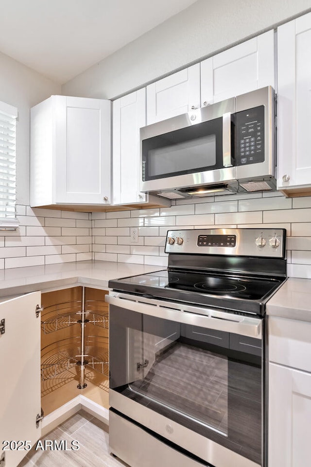 kitchen with white cabinetry, light countertops, appliances with stainless steel finishes, and decorative backsplash