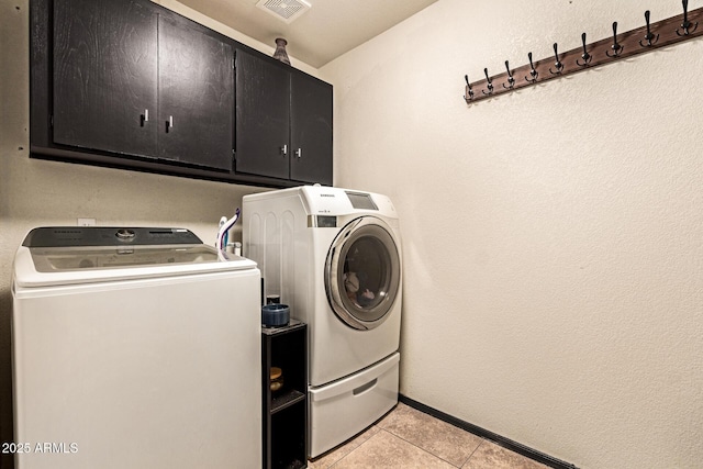 3032 W Red Fox Rd, Phoenix, AZ 85083 - laundry area featuring cabinet space, washing machine and dryer, light tile patterned floors, baseboards, and a textured wall