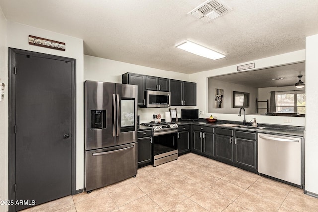 3032 W Red Fox Rd, Phoenix, AZ 85083 - kitchen with stainless steel appliances, a sink, dark countertops, dark cabinets, and light tile patterned floors