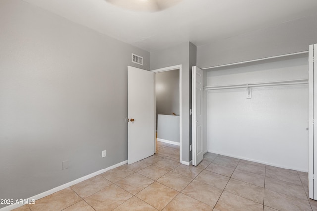 unfurnished bedroom featuring a closet and light tile patterned flooring