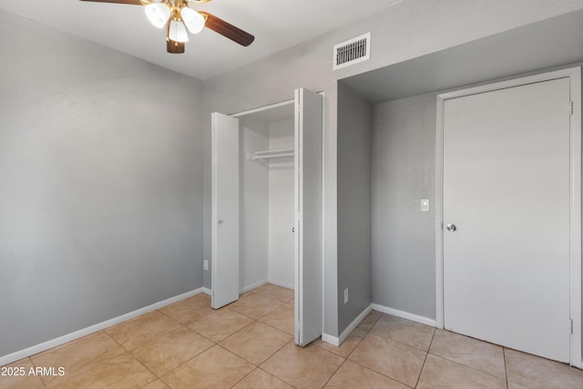 unfurnished bedroom with ceiling fan, light tile patterned flooring, and a closet