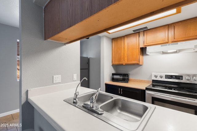 kitchen with sink, fridge, electric range, and light tile patterned flooring