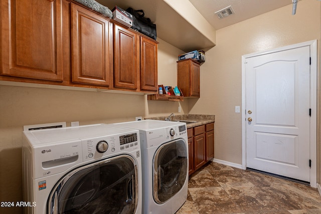 washroom with cabinets, sink, and washer and dryer