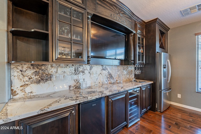 kitchen featuring wine cooler, stainless steel fridge with ice dispenser, dark brown cabinetry, light stone countertops, and dark wood-type flooring