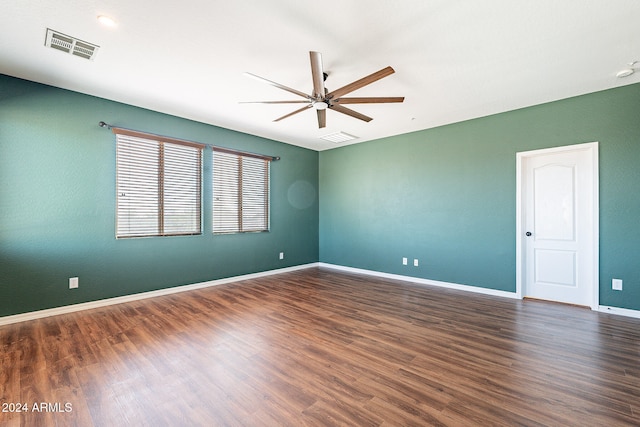 unfurnished room featuring dark wood-type flooring and ceiling fan