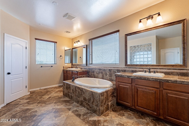 bathroom with vanity and tiled tub