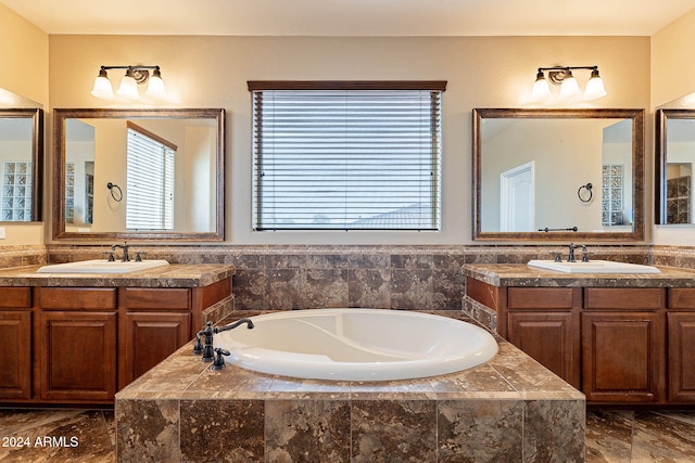 bathroom featuring tiled bath and vanity