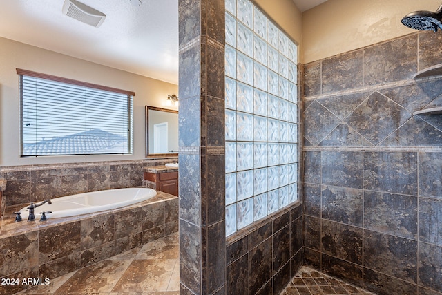 bathroom with vanity and shower with separate bathtub