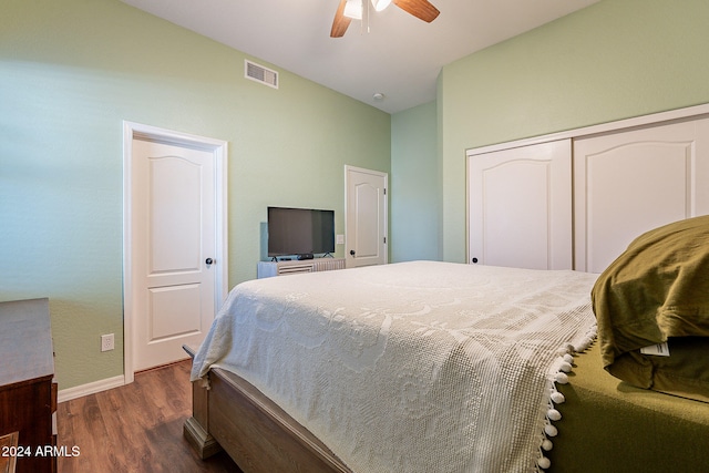 bedroom featuring dark wood-type flooring, a closet, and ceiling fan