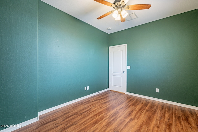 empty room with hardwood / wood-style floors and ceiling fan