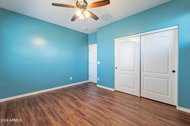 unfurnished bedroom with ceiling fan, a closet, and dark hardwood / wood-style flooring